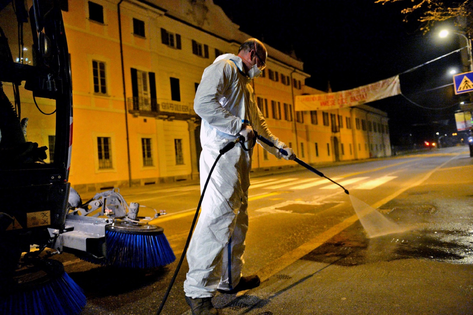 VARESE OPERATORI ASPEM IN TUTA, OCCHIALI E MASCHERINA, LAVANO STRADE E MARCIAPIEDI CON LANCIA E SPAZZATRICE, PER CORONAVIRUS