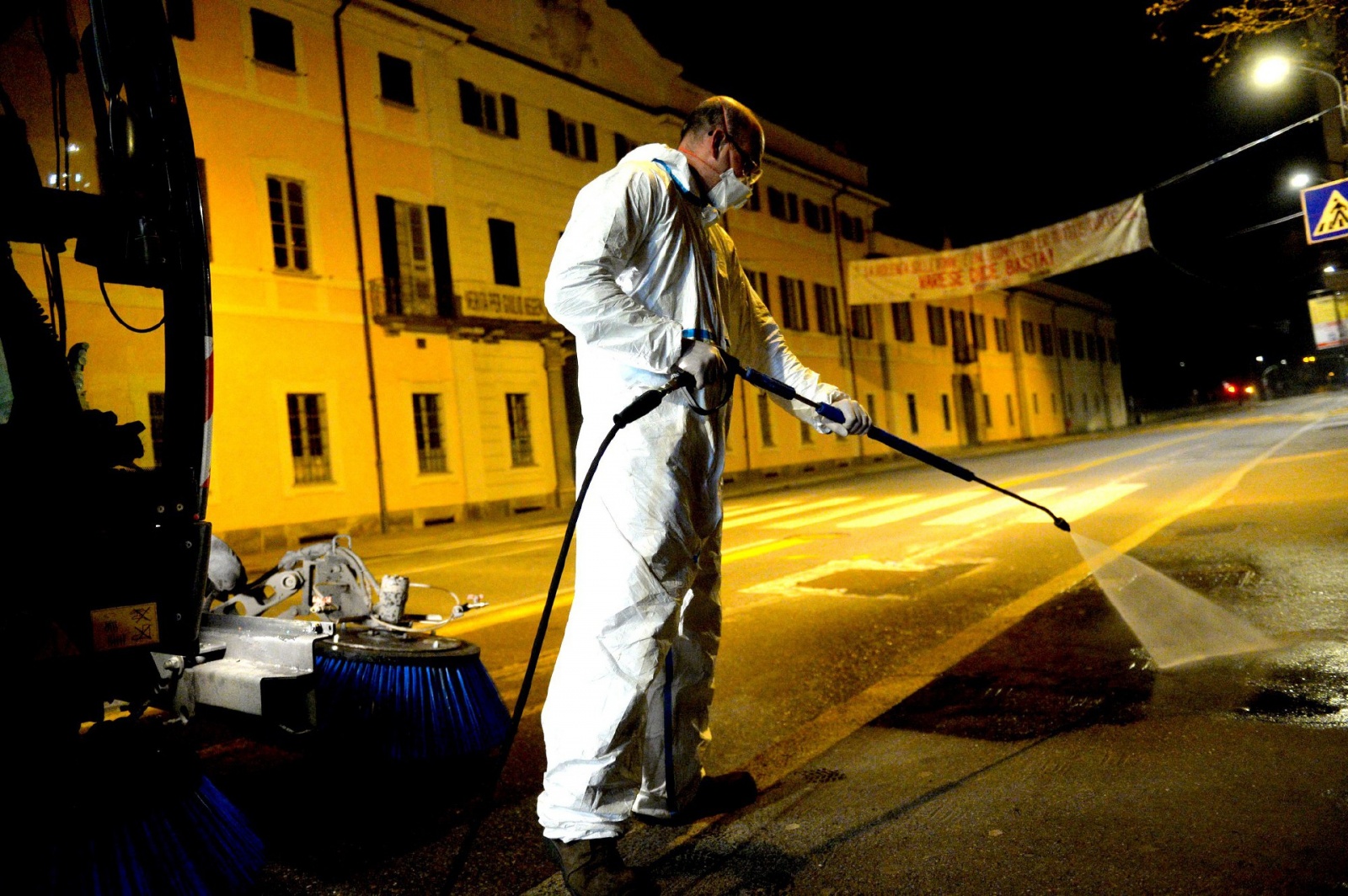 VARESE OPERATORI ASPEM IN TUTA, OCCHIALI E MASCHERINA, LAVANO STRADE E MARCIAPIEDI CON LANCIA E SPAZZATRICE, PER CORONAVIRUS