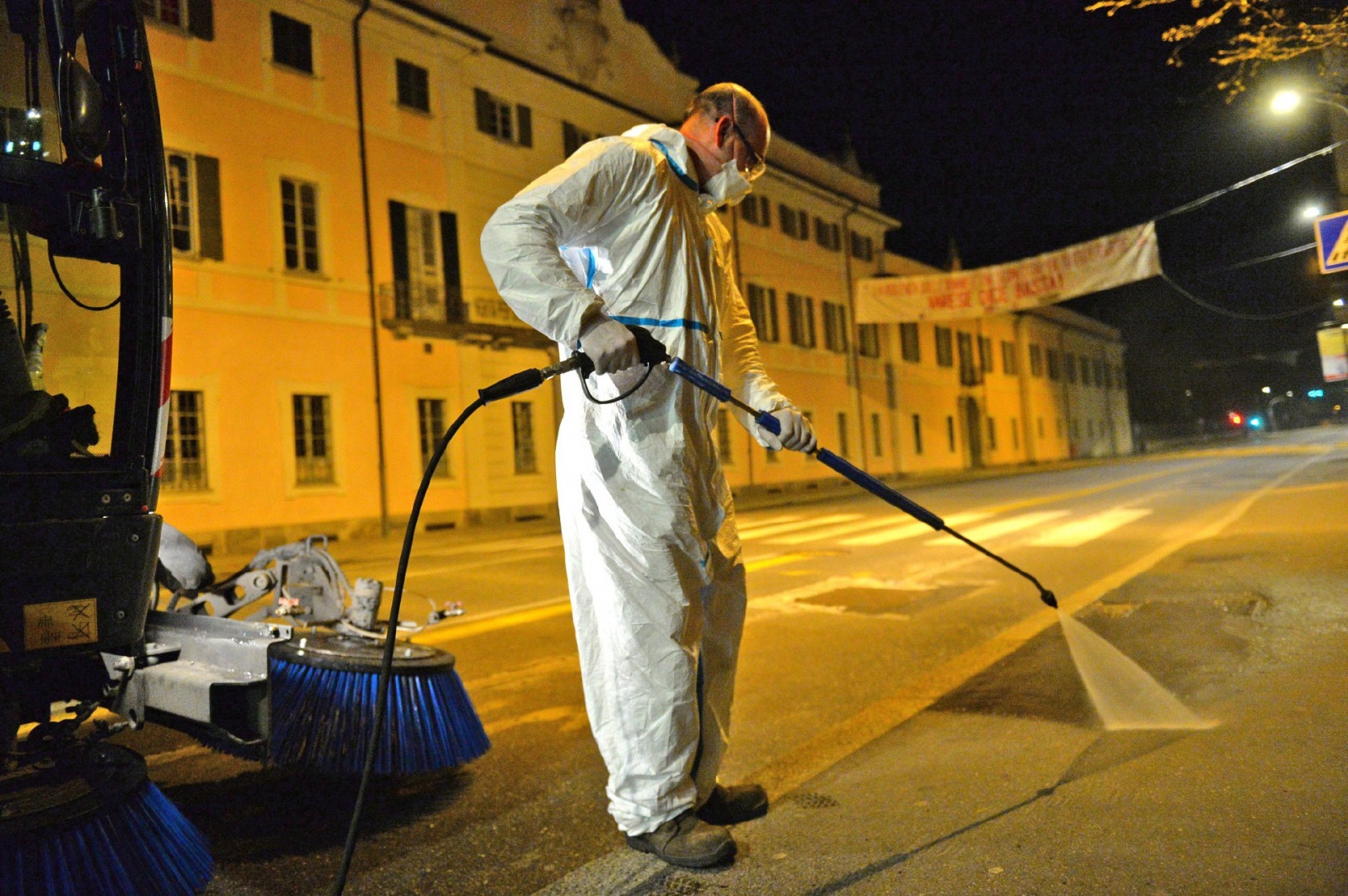 VARESE OPERATORI ASPEM IN TUTA, OCCHIALI E MASCHERINA, LAVANO STRADE E MARCIAPIEDI CON LANCIA E SPAZZATRICE, PER CORONAVIRUS