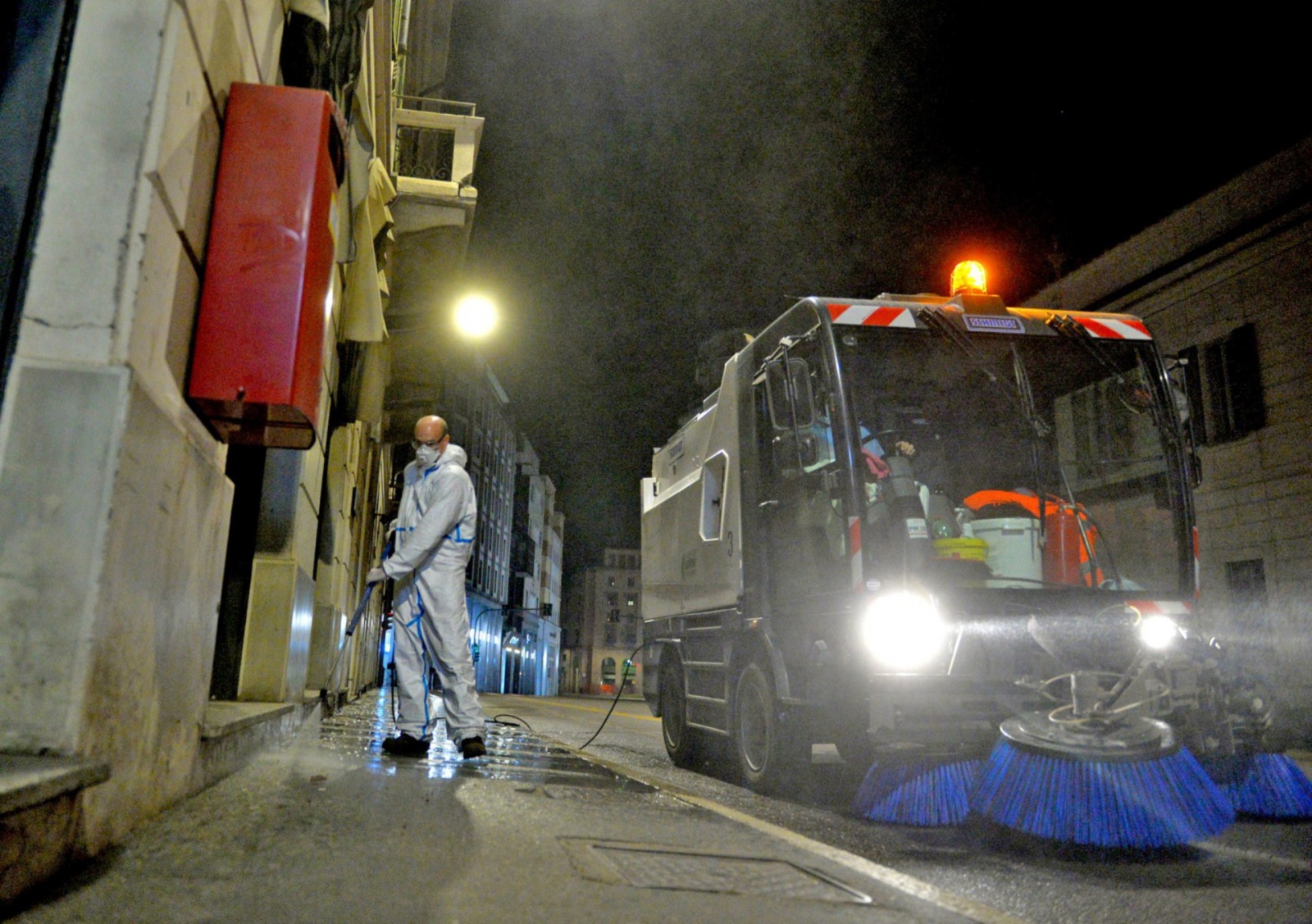 VARESE OPERATORI ASPEM IN TUTA, OCCHIALI E MASCHERINA, LAVANO STRADE E MARCIAPIEDI CON LANCIA E SPAZZATRICE, PER CORONAVIRUS
