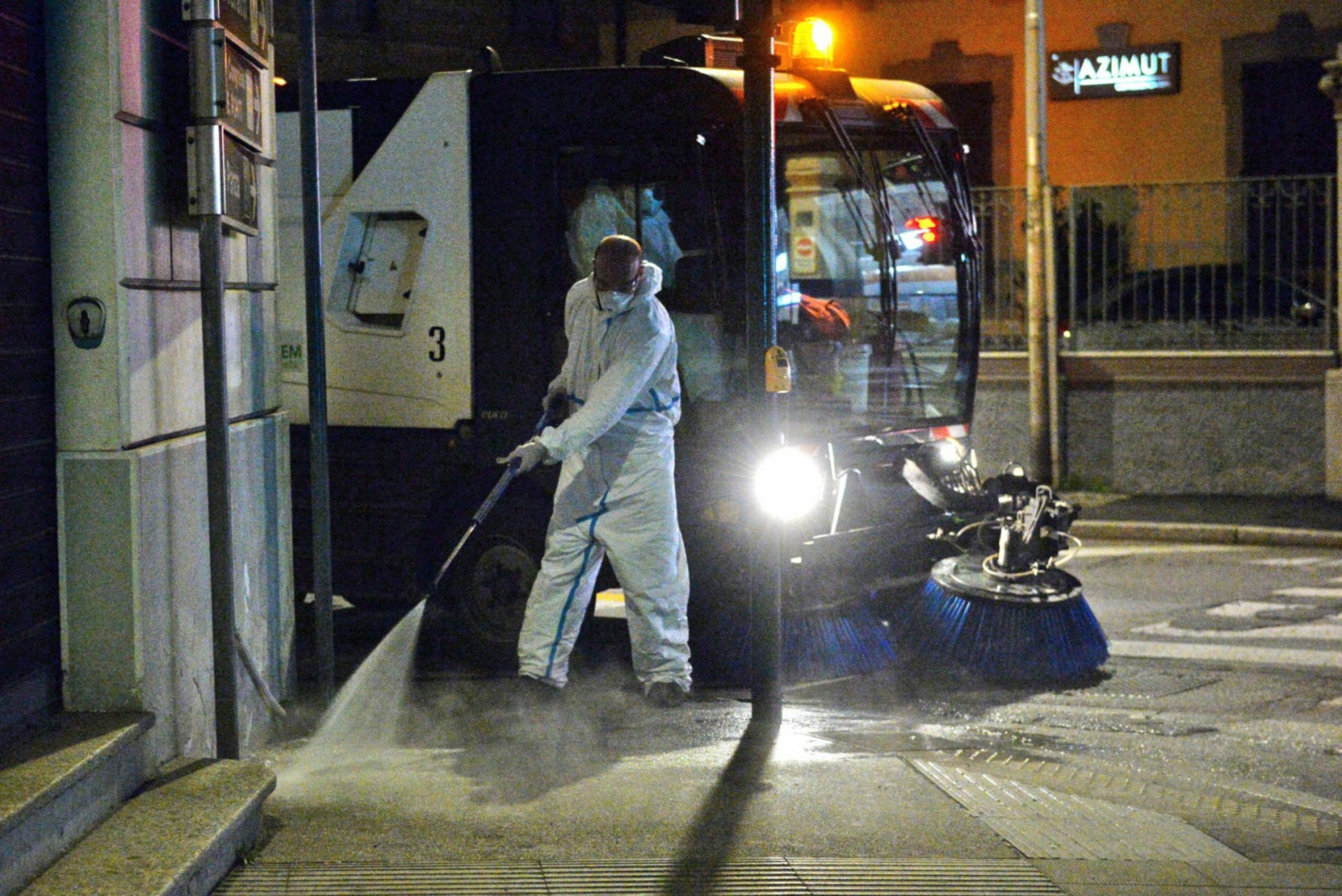 VARESE OPERATORI ASPEM IN TUTA, OCCHIALI E MASCHERINA, LAVANO STRADE E MARCIAPIEDI CON LANCIA E SPAZZATRICE, PER CORONAVIRUS
