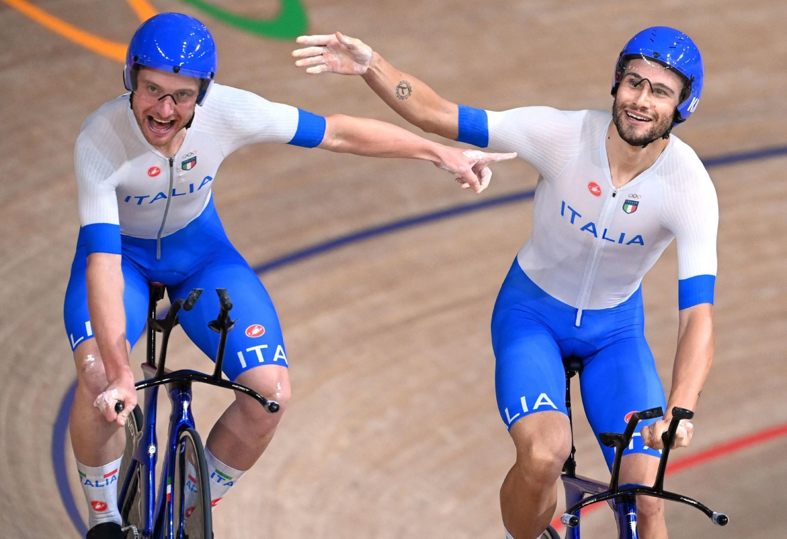 Italy's Simone Consonni (L) and Italy's Filippo Ganna celebrate after winning gold and setting a new World Record in the men's track cycling team pursuit finals during the Tokyo 2020 Olympic Games at Izu Velodrome in Izu, Japan, on August 4, 2021. (Photo 