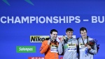 Bronze medallist USA's Nic Fink (R), Silver medallist Netherlands' Arno Kamminga (L) and Gold medallist Italy's Nicolo Martinenghi pose with their medals following the men's 100m breaststroke finals the Budapest 2022 World Aquatics Championships at Duna A