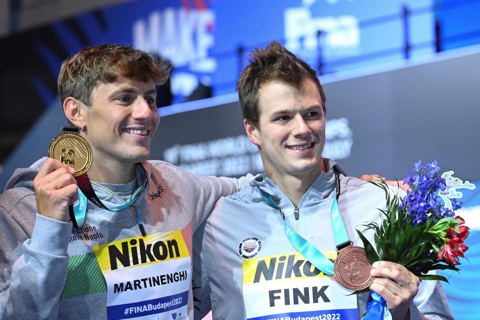 Gold medallist Italy's Nicolo Martinenghi (L) and Silver medallist USA's Nic Fink pose with their medals following the men's 100m breaststroke finals the Budapest 2022 World Aquatics Championships at Duna Arena in Budapest on June 19, 2022. (Photo by Fere