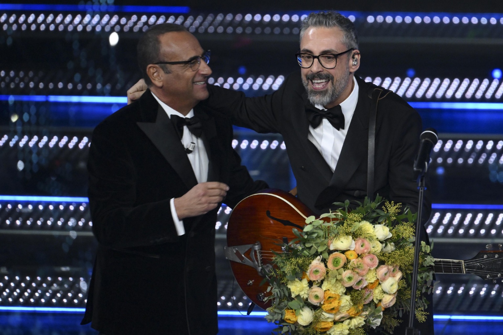 Italian singer Brunori Sas (R) and R) and Sanremo Festival host and artistic director Carlo Conti on stage at the Ariston theatre during the 75th edition of the Sanremo Italian Song Festival, in Sanremo, Italy, 15 February 2025. The music festival will ru