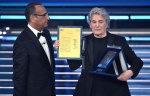 Italian singer Fausto Leali (R) poses after receiving the 'Citta' di Sanremo' award next to Sanremo Festival host and artistic director Carlo Conti on stage at the Ariston theatre during the 76th edition of the Sanremo Italian Song Festival, in Sanremo, I