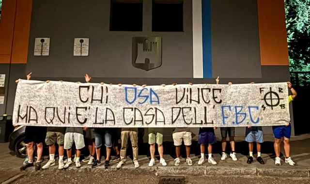 Gli ultras del Saronno con lo striscione davanti allo stadio