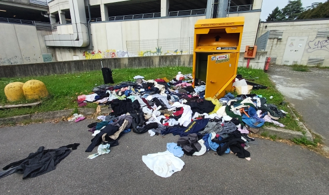 Cassonetto forzato, vestiti gettati nel parcheggio