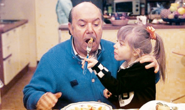 Annuccia (Eleonora Cadeddu, oggi 29) imbocca nonno Libero (Lino Banfi, 88) in una scena di Un medico in famiglia, storica fiction in onda su Rai 1 dal 1998 al 2016