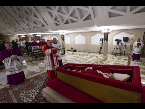 Il Papa nella bara, casula rossa e rosario tra le mani