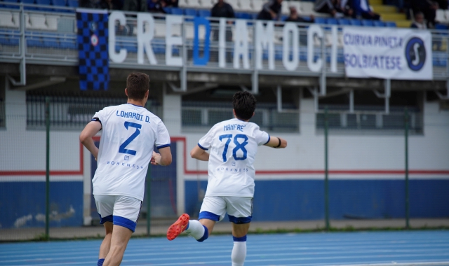 Esulta Manfrè, che ha aperto e chiuso il match contro il Mariano, sotto lo striscione che i tifosi della Solbiatese hanno esposto per caricare la squadra (foto Samuele Lucchi)