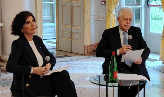 Nella foto sopra, Mario Monti intervistato da Rosi Brandi. Qui, la firma su un gioco in cui il prof appare su una banconota