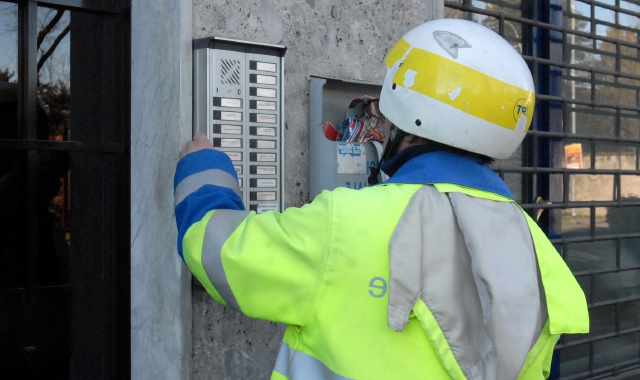 In alto l’ufficio postale di via Varese. Sopra, un postino al lavoro