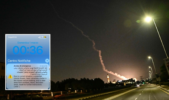 L’esplosione di un razzo intercettato visibile sabato a tarda sera nel cielo di Dubai. Nel riquadro, l’alert ricevuto a mezzanotte e 36 minuti (21.36 in Italia) sui telefonini degli studenti  bloccati