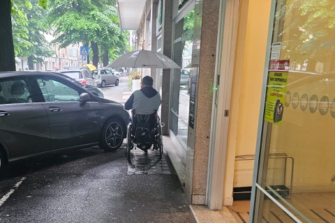 Auto sul marciapiede, disabile bloccato