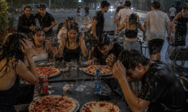Nella foto (generata dall’intelligenza artificiale) la disavventura accaduta a una classe di liceali che si è ritrovata a mangiare la pizza sotto l’acqua. 